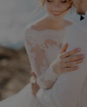Foto de um casal recém casados, vestimenta da mulher é um vestido branco de casamento